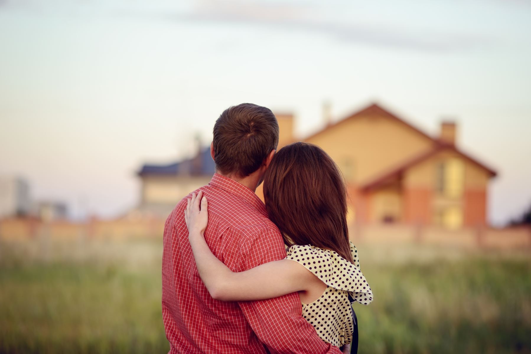 Man and woman hugging and looking at home